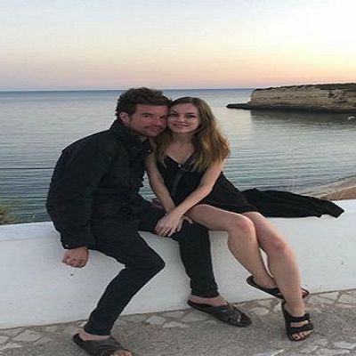 They are wearing all black as they are posing with ocean in the background.